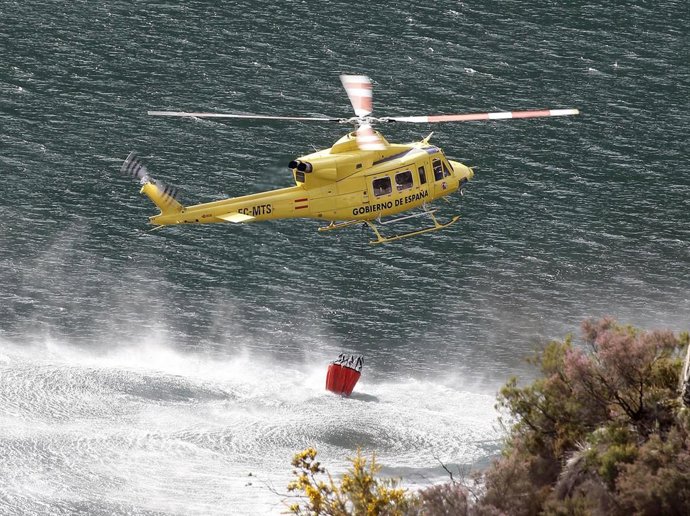 Archivo - Un helicóptero trabaja en la extinción de un incendio en Soto de Los infantes, concejo de Salas, Gijón, Asturias. 