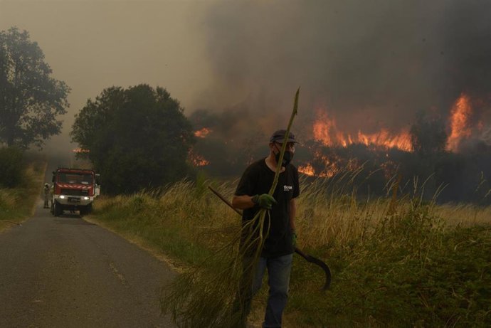 Veciños e veciñas de Vilela mentres se achegan as chamas á localidade, a 15 de agosto de 2025, en Vilela, Cualedro, Monterrei, Ourense, Galicia (España). 