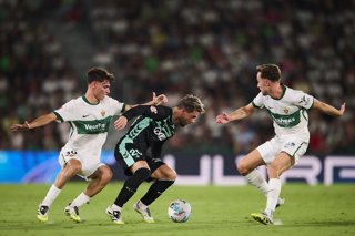 Giovani Lo Celso of Real Betis competes for the ball with Rodrigo Mendoza of Elche CF during the Spanish League, LaLiga EA Sports, football match played between Elche FC and Real Betis Balompie at Estadio Manuel Martinez Valero on August 18, 2025 in Elche