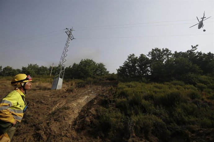 Helicóptero bombardero continúa con la tareas de extinción para sofocar el incendio forestal.