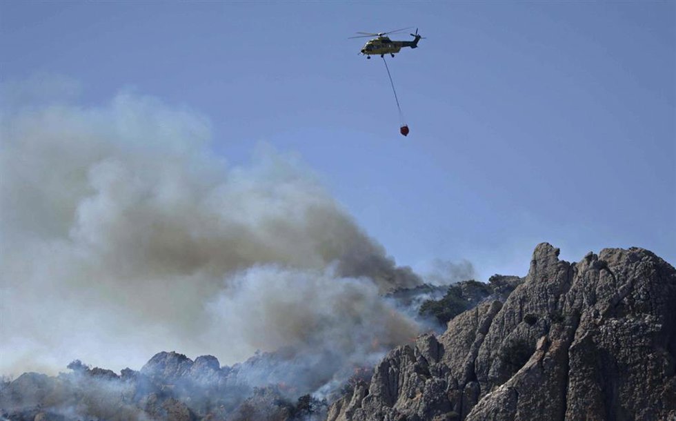 Medios terrestres y aéreos operan en el incendio declarado en el paraje Sierra de la Plata, cercano a la playa de Bolonia, a 11 de agosto de 2025, en Tarifa (Cádiz, Andalucía, España). 