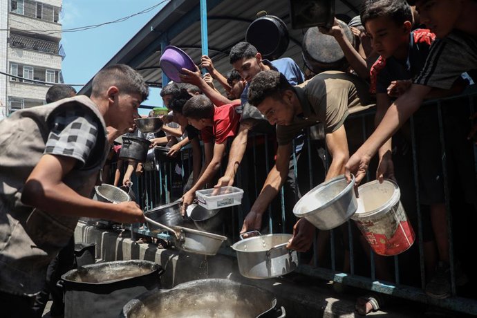 GAZA, 19 de agosto de 2025 -- Palestinos deslocados esperam para receber alimentos gratuitos em um centro de distribuição na Cidade de Gaza, em 18 de agosto de 2025.