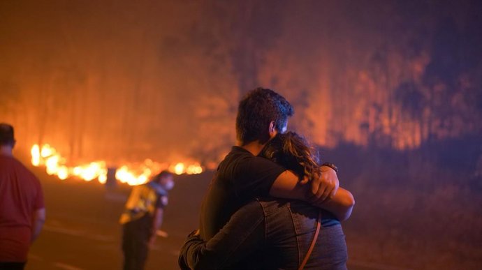 Archivo - Dos personas se abraza en las inmediaciones del incendio, a 5 agosto de 2022,  en O Vento, parroquia de Cea, en la comarca de Salnes y el concello de Villagarcía de Arousa, Pontevedra, Galicia (España). El incendio forestal declarado en la tarde