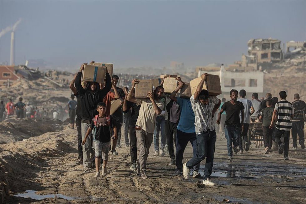 Archivo - Imagen de archivo de un grupo de palestinos tras recibir ayuda en la Franja de Gaza.
