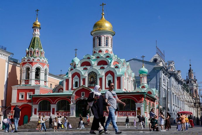 RUSSIA, MOSCOW - AUGUST 15, 2025: Citizens stroll about Red Square, with the Kazan Cathedral in the background