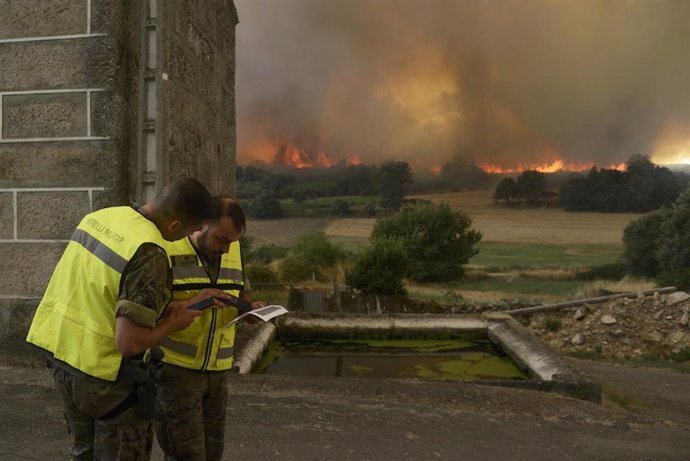 Vecinos y vecinas de Vilela, en Cualedro, mientras se acercan las llamas a la localidad