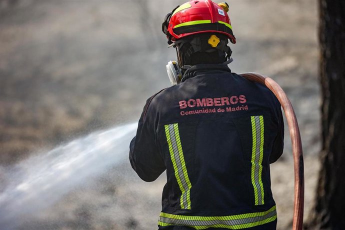 Un bombero de la Comunidad de Madrid sujeta una manguera para extinguir un incendio, a 19 de agosto de 2025, en Colmenar Viejo, Madrid (España). 