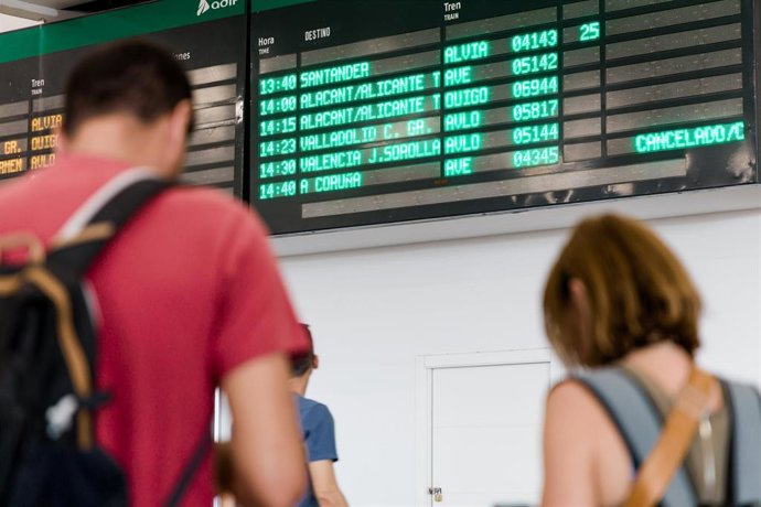 Varias personas esperan con maletas, junto a los carteles de salidas, en la estación Chamartín Clara Campoamor, a 19 de agosto de 2025, en Madrid