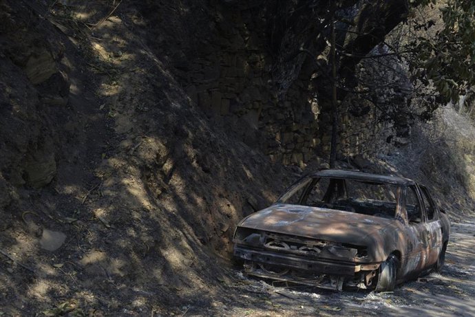 Un coche calcinado tras el incendio en San Vicente de Leira en Villamartín de Valdeorras, Ourense
