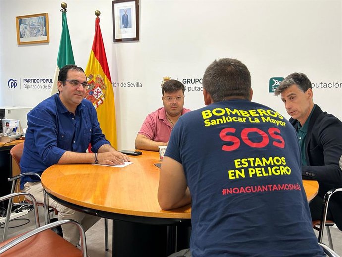 El portavoz del PP en la Diputación de Sevilla, Martín Torres, junto a bomberos de la provincia de Sevilla.