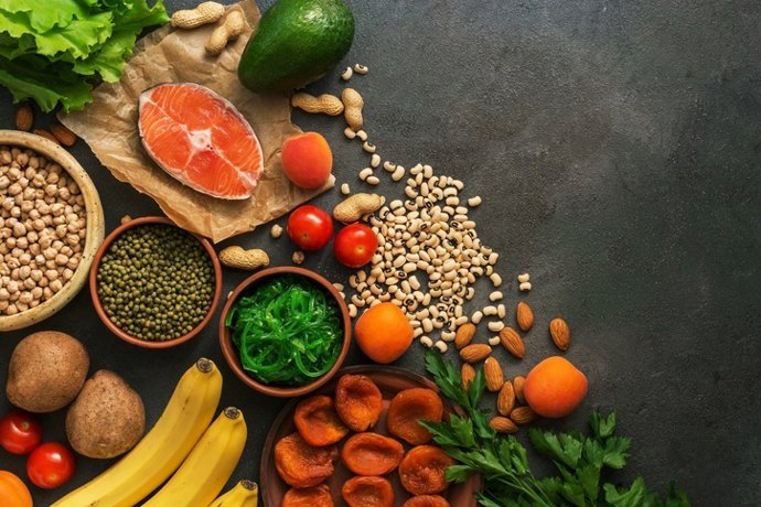 Archivo - Arquivo - Alimentos saudáveis ricos em potássio. Uma variedade de leguminosas, salmão, frutas, verduras, damascos secos, chuka de algas marinhas e nozes em um fundo escuro.