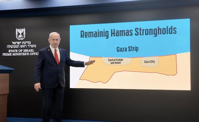 JERUSALÉM, 11 de agosto de 2025 -- Esta foto tirada com um telefone celular mostra o primeiro-ministro israelense Benjamin Netanyahu apontando para um mapa da Faixa de Gaza na tela durante uma conferência de imprensa em Jerusalém, em 10 de agosto de 2025.