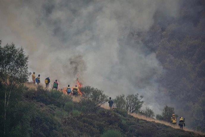 Varias personas tratan de extinguir un fuego, a 19 de agosto de 2025, en el Puerto de San Glorio, León, Castilla y León (España). 
