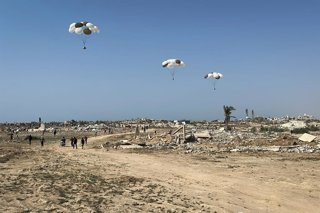 14 August 2025, Palestinian Territories, Nuseirat: Palestinians rush to retrieve aid packages parachuted during an airdrop over Nuseirat in the central Gaza Strip. Photo: Belal Abu Amer/APA Images via ZUMA Press Wire/dpa