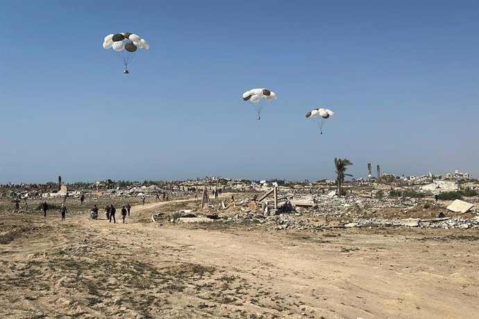 14 August 2025, Palestinian Territories, Nuseirat: Palestinians rush to retrieve aid packages parachuted during an airdrop over Nuseirat in the central Gaza Strip. Photo: Belal Abu Amer/APA Images via ZUMA Press Wire/dpa