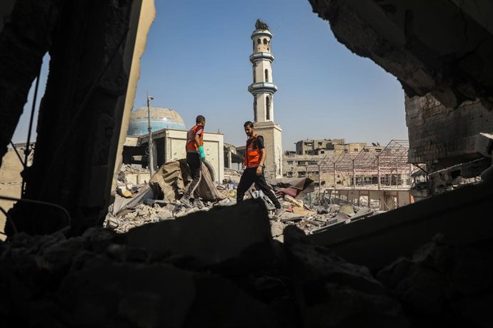 GAZA, 16 de agosto de 2025 -- Funcionários da defesa civil palestina inspecionam uma casa destruída após um ataque aéreo israelense, na Cidade de Gaza, em 15 de agosto de 2025. PARA IR COM "Reportagem: Desafiadores nos escombros de Gaza, equipes de resgat