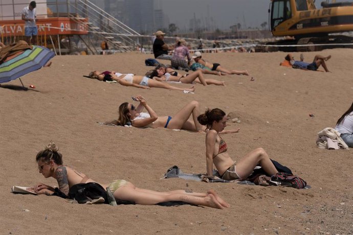 Archivo - Varias personas toman el sol en la playa de la Barceloneta, a 25 de abril de 2023, en Barcelona, Catalunya (España). 