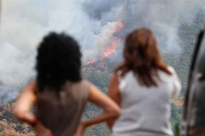 Varias personas observan el incendio, en la sierra de O Courel.