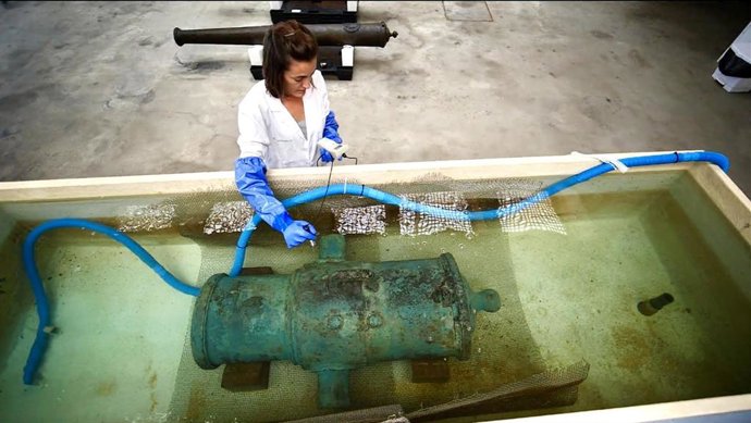 Imagen de una trabajadora haciendo una tarea de conservación de metal arqueológico de procedencia subacuática.
