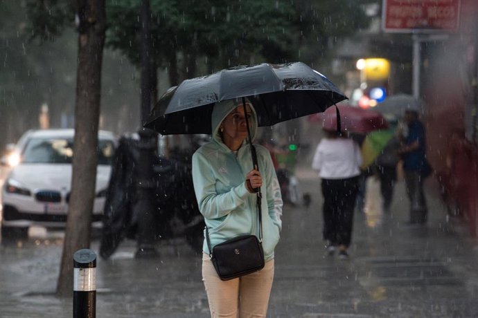 Archivo - Una mujer con paraguas bajo la lluvia, a 29 de mayo de 2023, en Madrid (España). 