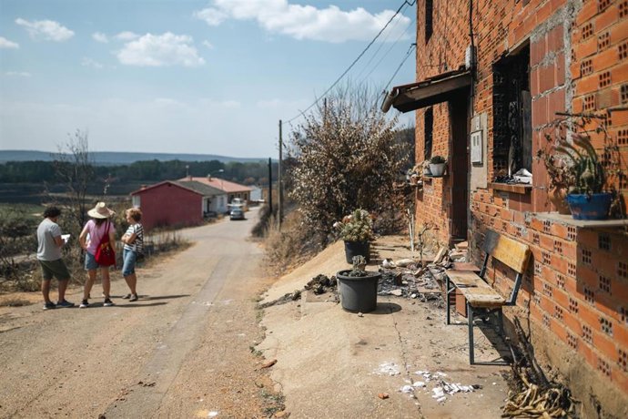 Vecinas de Castrocalbón junto a una vivienda que ha sido destruida por los incendios, a 20 de agosto de 2025, en Castrocalbón, León, Castilla y León (España).
