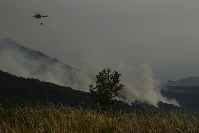 Un helicóptero tira agua sobre el fuego para extinguir el incendio, a 2 de agosto de 2025, en Vilardevós, Ourense, Galicia (España).