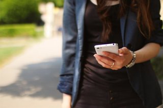 Archivo - Persona usando un teléfono móvil.