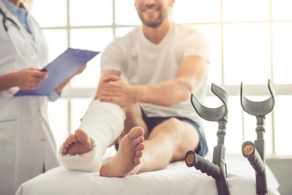 Archivo - Imagen de recurso de un hombre con una pierna escayolada y muletas, en la consulta del médico.