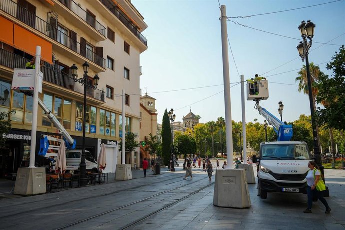 Operarios realizan los trabajos previos a la colocación de los toldos que darán sombra a la Avenida de la Constitución de Sevilla. A 22 de agosto de 2025, en Sevilla (Andalucía, España). 