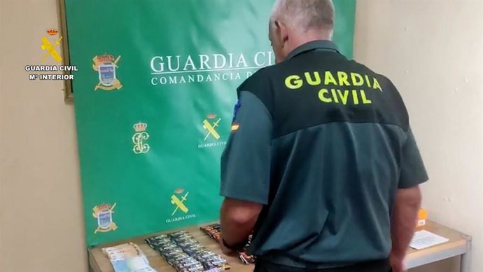 Un agente de la Guardia Civil con el material intervenido en la operación.