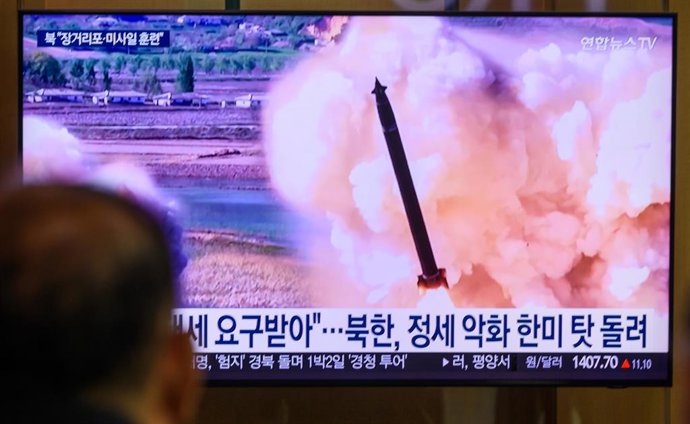 Archivo - May 9, 2025, Seoul, South Korea: People look at a 24-hour Yonhap news TV broadcast at Seoul Railway Station showing a news broadcast with a joint striking drill of long-range artillery and missile systems of the Korean People's Army eastern fron