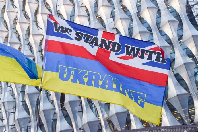 Archivo - March 5, 2025, London, United Kingdom: A protester holds a part-Ukrainian, part-UK flag with the slogan 'We stand with Ukraine' during the demonstration. Crowds gathered outside the Embassy of USA in protest against Trump and Putin following Tru