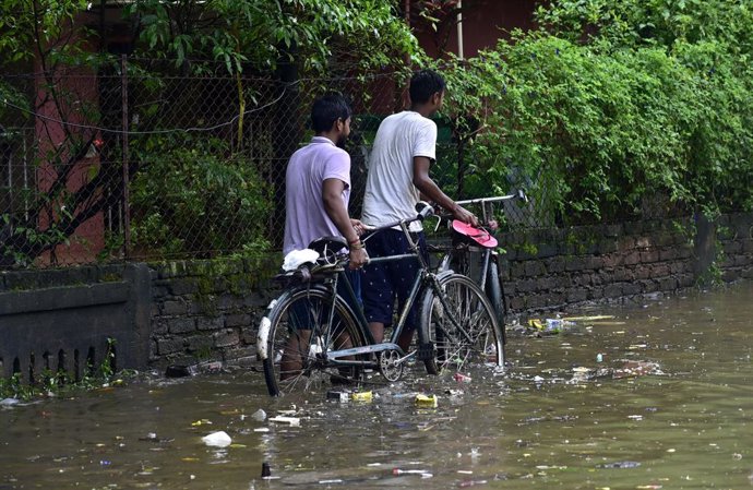 August 13, 2025, Guwahati, Guwahati, India: Commuters  wades through the flooded  street after rain  in Guwahati India  on Wednesday 13th August 2025.