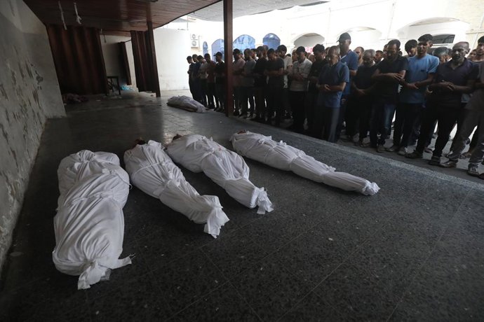 15 de agosto de 2025, Cidade de Gaza, Faixa de Gaza, Território Palestino: Pessoas fazem orações fúnebres depois que os corpos de palestinos, incluindo crianças que perderam a vida, são levados ao Hospital Al-Ahly para uma cerimônia fúnebre após o ataque 