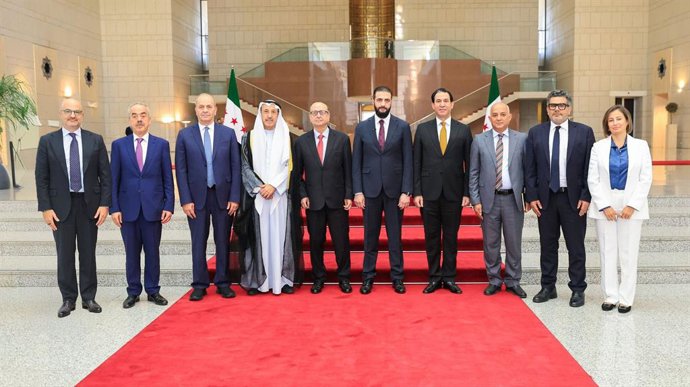 O presidente sírio Ahmed al Shara, ao centro, acompanhado por jornalistas árabes.