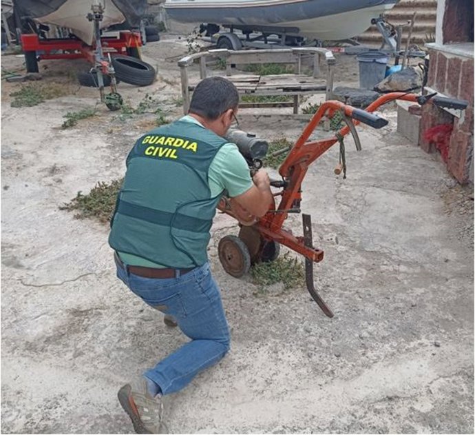 Un agente de la Guardia Civil con uno de los motocultores sustraídos en una finca de Tacoronte