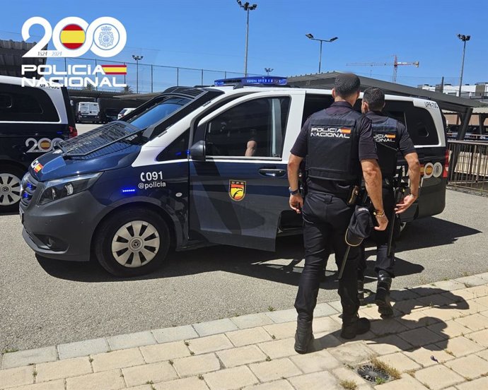 Dos agentes de la Policía Nacional, de espaldas.