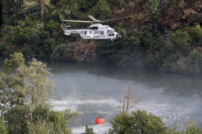 Un helicóptero colabora en las labores de extinción del incendio, a 19 de agosto de 2025, en Quiroga, Lugo