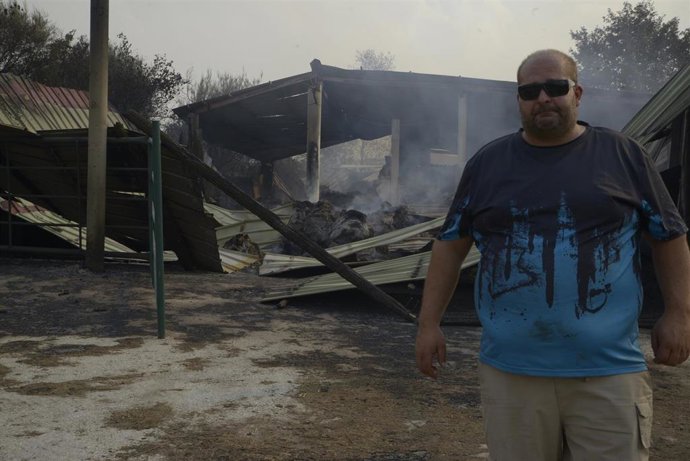 Un ganadero observa el estado de su granja tras el paso del fuego en Cova, Pobra de Trives, Ourense, Galicia (España). 