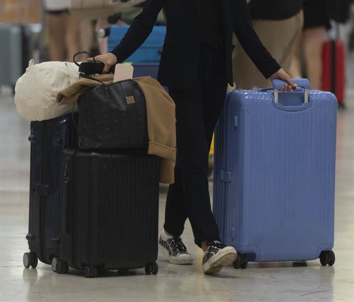Una persona con maletas en un aeropuerto.