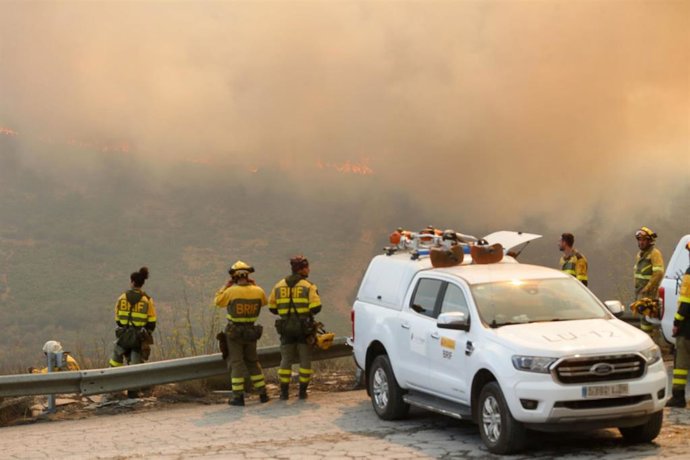 Un grupo de bomberos observan el incendio forestal, a 24 de agosto de 2025, en La Baña, Encinedo, La Cabrera, León, Castilla y León (España)