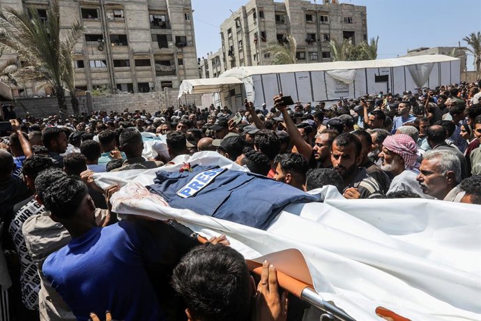 26 de agosto de 2025, Territórios Palestinos, Khan Younis: Palestinos carregam o corpo de um jornalista que foi morto em um ataque israelense ao Hospital Nasser em Khan Younis. A agência de defesa civil de Gaza disse que cinco jornalistas foram mortos ent