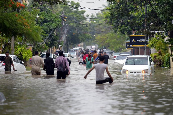 Imatge d'arxiu de diverses persones en un carrer negat per les fortes inundacions en Pakistan.