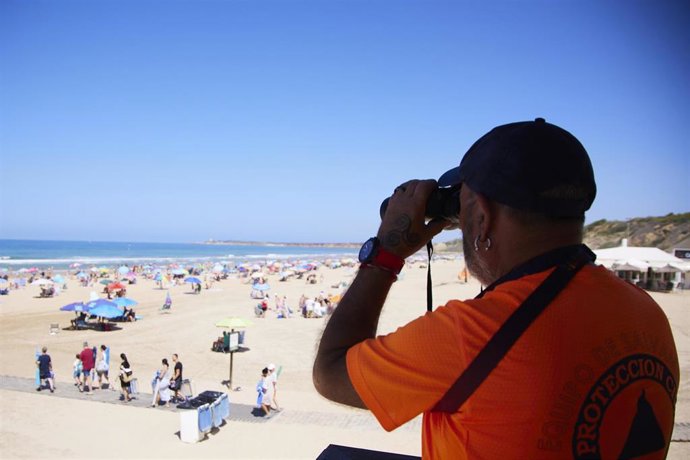 Archivo - Un vigilante de la playa observa a los bañista desde su torre en la playa de la Fontanilla en Conil de la Frontera, a 8 de julio de 2023 en Cádiz (Andalucía, España). 