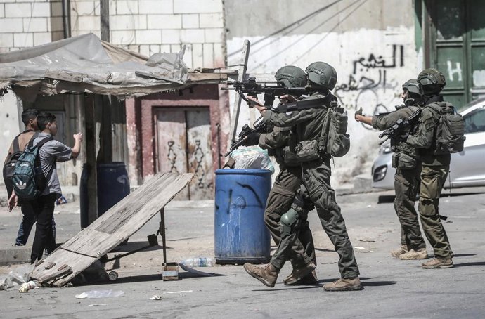 Archivo - Arquivo - 28 de abril de 2025, Nablus, Cisjordânia, Palestina: Soldados israelenses impedem que crianças em idade escolar passem pela rua durante um ataque ao campo de refugiados de Al-Ain, perto da cidade de Nablus, na Cisjordânia. As forças is