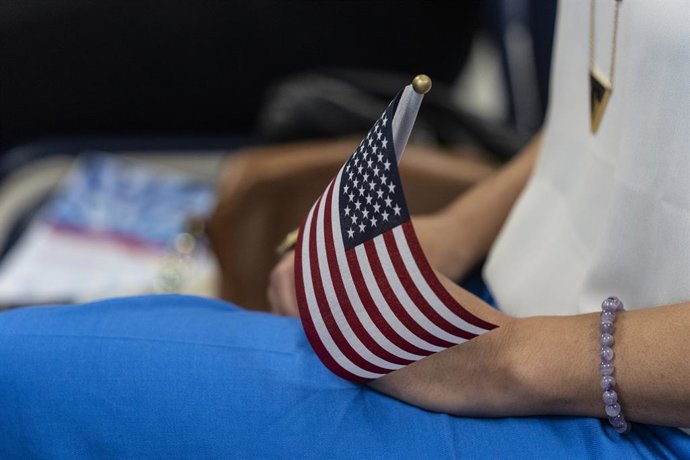 Archivo - 1º de junho de 2022, Nova York, Nova York, Estados Unidos: Uma mulher segura uma bandeira americana durante a cerimônia de naturalização do Memorial Day no escritório distrital do USCIS em Nova York. 102 pessoas originárias de 38 países se torna