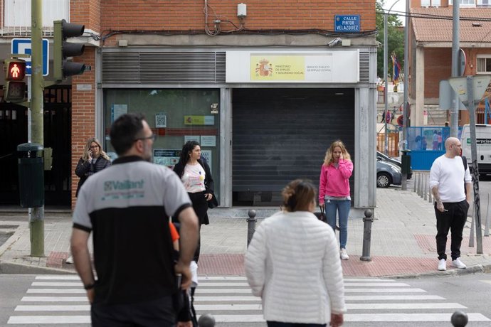 Archivo - Varias personas frente a una oficina del servicio público de empleo (SEPE)