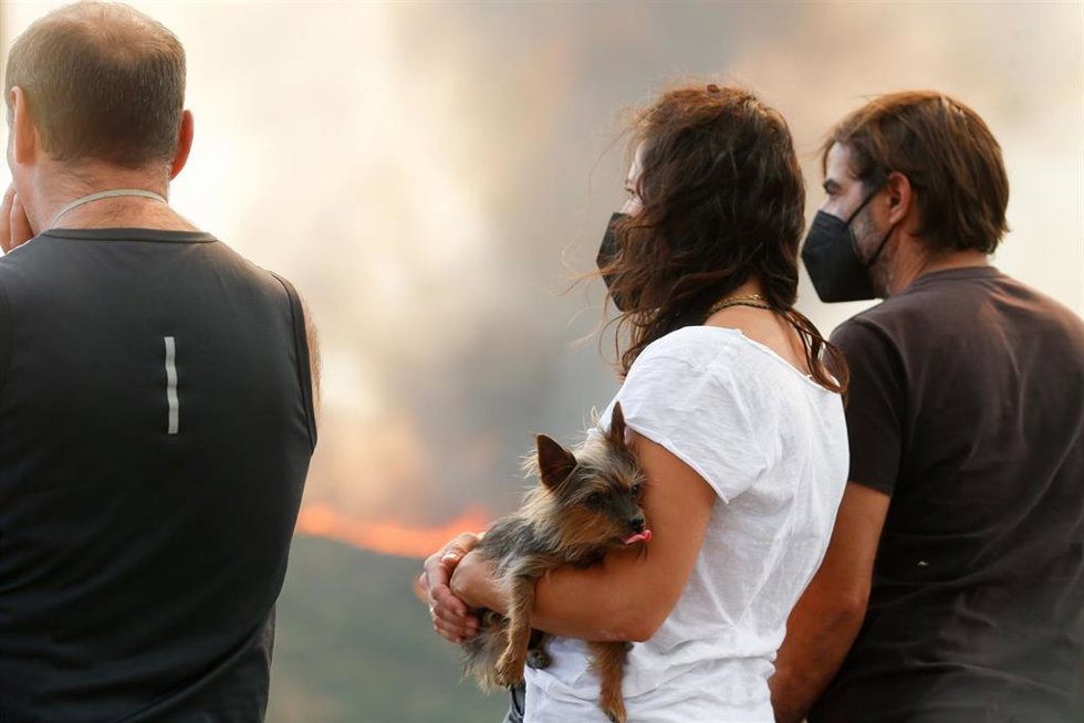 Varias personas observan el incendio forestal, a 24 de agosto de 2025, en La Baña, Encinedo, La Cabrera, León, Castilla y León (España). La evolución del incendio forestal procedente de Porto (Zamora) ha sido favorable durante la noche, aunque se ha a