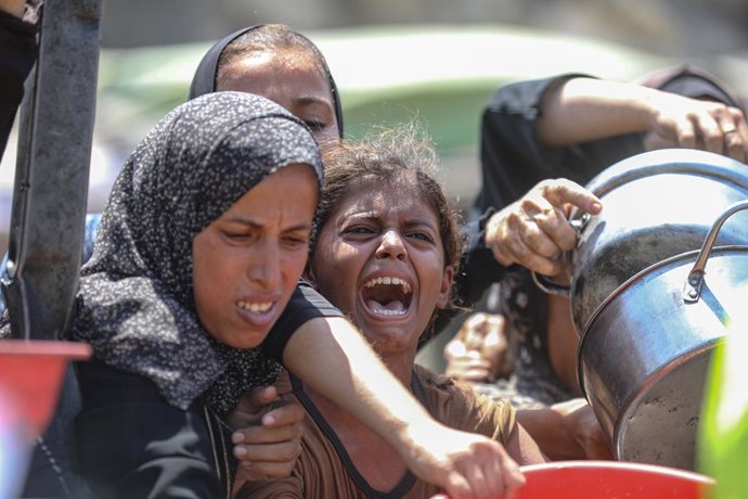 24 de agosto de 2025, Cidade de Gaza, Faixa de Gaza, Território Palestino: Palestinos esperam para receber comida de uma cozinha de caridade, em meio a uma crise de fome, na Cidade de Gaza, em 24 de agosto de 2025