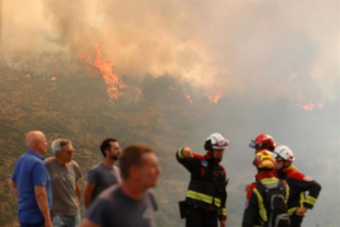 Varias personas observan el incendio forestal en La Baña, Encinedo, La Cabrera, León.